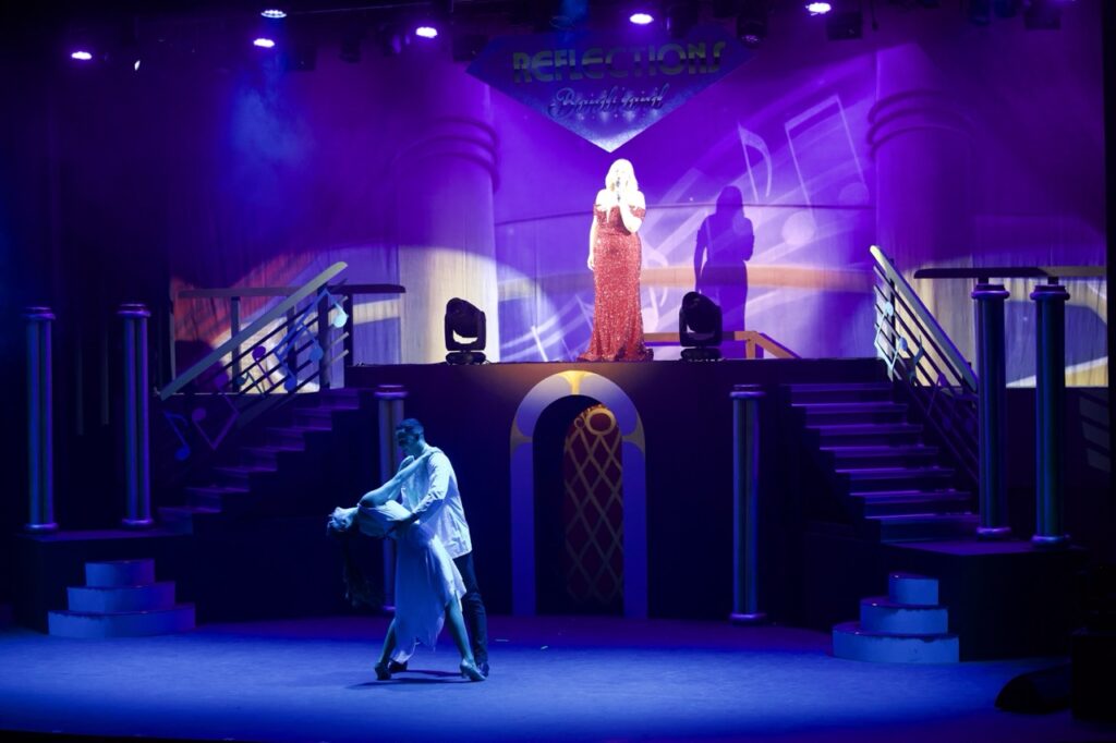 woman in red dress on platform singing
