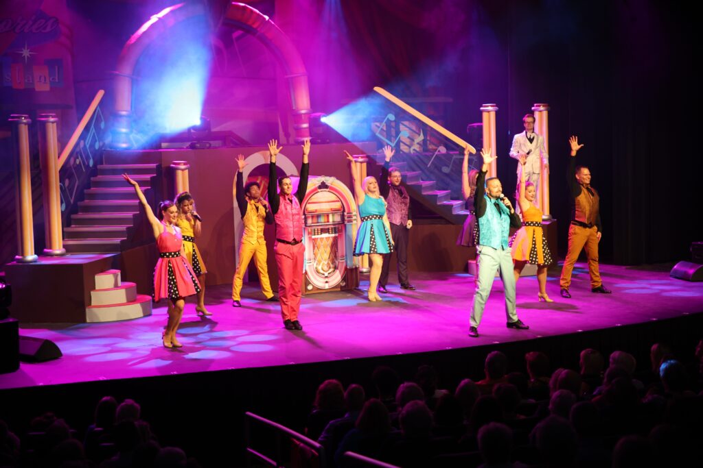 cast of singers on stage jukebox set